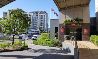 a view of a city street with tall buildings and a parking lot in front of a building at Ibis Sydney Airport