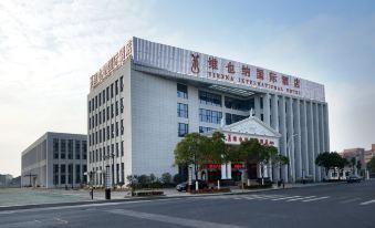 The large, modern building in an urban setting has front and side views at Vienna International Hotel (Shanghai Pudong Airport Free Trade Zone)