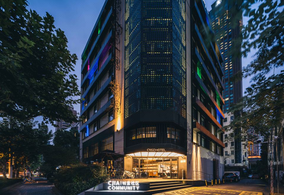 At night, there is a hotel in the foreground and an illuminated building in the background at CitiGO Hotel Jing'an Shanghai