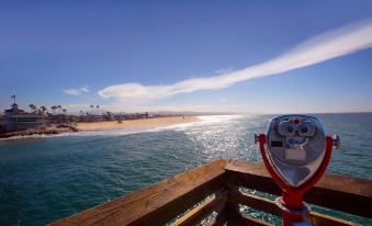 a view of the ocean with a red and white telescope pointed towards it , taken from a wooden railing at Homewood Suites by Hilton Aliso Viejo Laguna Beach