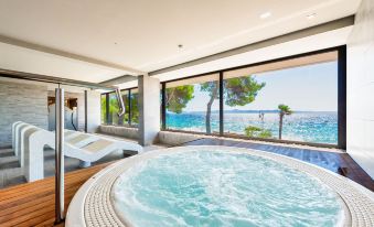 a modern bathroom with a large bathtub situated in front of a window overlooking the ocean at Hotel Pinija