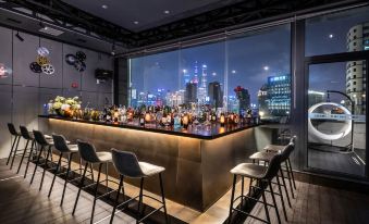 The rooftop terrace of the hotel features a bar with chairs and offers a scenic outside view at Mehood Elegant Hotel Shanghai Bund
