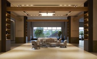 a spacious , well - lit living room with multiple couches and chairs arranged around a coffee table at Lahan Hotel Jeonju