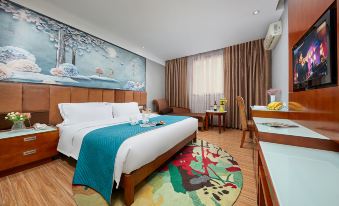In the middle room, there is a large bed with an orange accent wall and a matching table beside it at Kaiserdom Hotel (Guangzhou Baiyun Airport)