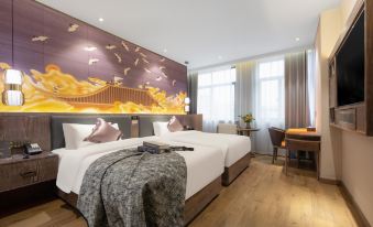 a spacious bedroom with two double beds and a large table in the center at Manxin Hotel