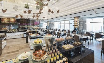 The restaurant is filled with guests dining at their own tables, which are positioned near large windows at Baiyun Hotel