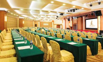a large conference room with rows of chairs arranged in a semicircle , and a podium at the front of the room at City Hotel