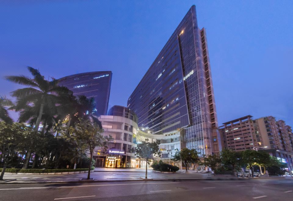 At night, a large building in the middle is illuminated by street lights, offering an outside view at Home·NEO Hotel (Guangzhou Exhibition Center Pazhou Metro Station)