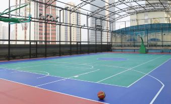 The indoor basketball court is equipped with an outdoor play area and a nearby building at Asia International Hotel