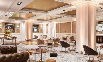 a large , elegant hotel lobby with multiple couches and chairs arranged in a comfortable seating area at Four Seasons Hotel Madrid