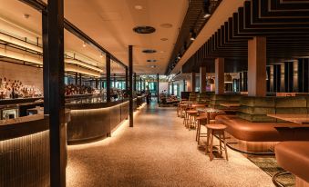 a modern bar with wooden stools and chairs , creating an inviting atmosphere for patrons to enjoy drinks and socialize at Marion Hotel