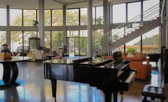 a large , open room with a grand piano in the center and multiple chairs and couches arranged around it at Haile Resort Hawassa