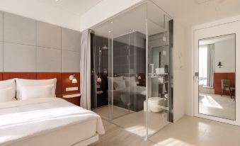 bedroom with a large glass wall and a white bed in the center, adjacent to a connected space at Novotel Shanghai Hongqiao exhibition center hotel