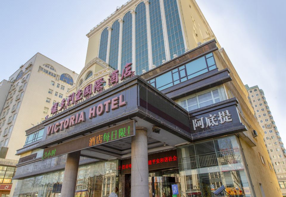"a large hotel building with a sign that reads "" victoria hotel "" prominently displayed on the front of the building" at Victoria International Hotel