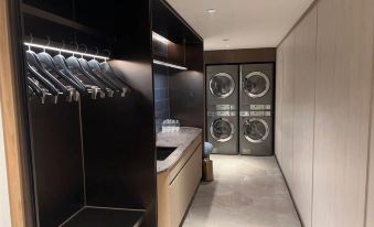 A room with laundry facilities, including washing machines and dryers, located next to an open door at Crystal Orange Beijing Shangdi Zhongguancun Software Park Hotel