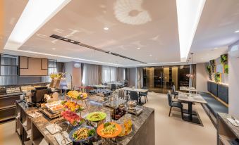 A spacious room with tables and chairs in the center, accompanied by an open kitchen concept at Home Inn (Shanghai Pudong Airport)