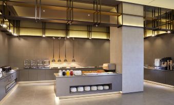 a modern restaurant with a long counter and various appliances , including a refrigerator and a microwave at Lahan Hotel Jeonju