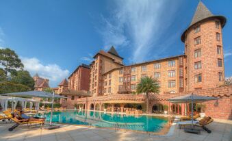 a large hotel with a pool surrounded by palm trees , providing a serene and inviting atmosphere at The Chateau Spa & Wellness Resort