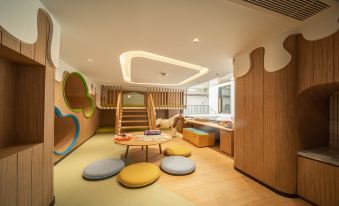 The children's room features a spacious bed and a play area equipped with built-in bookshelves at Homm Sukhumvit34 Bangkok