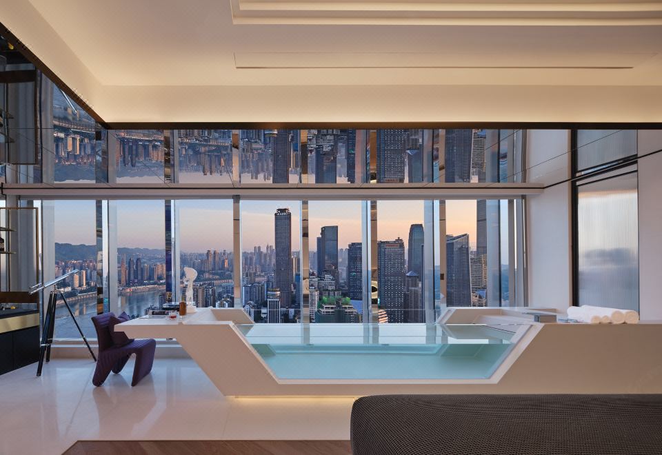 A photo taken from the living room captures a panoramic city view through large windows at ISEYA HOTEL Chaotianmen Chongqing