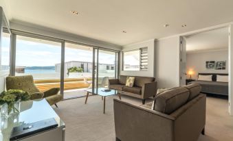 a modern living room with large windows and sliding glass doors leading to an outdoor balcony at Sacred Waters Taupo