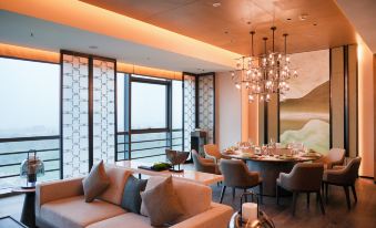 There is a modern dining room with large windows and an elegant chandelier over the table at Shantou Marriott Hotel