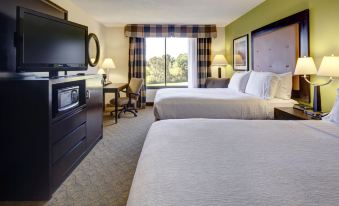 a hotel room with two beds , a tv , and a window , all decorated in white and brown colors at Holiday Inn Staunton Conference Center