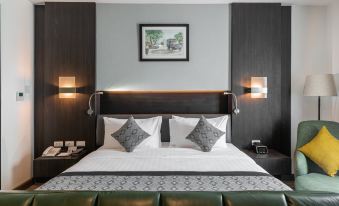 a large bed with a white and green headboard is in a room with two lamps on either side at SureStay Hotel by Best Western Vientiane