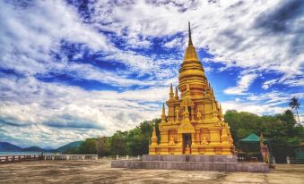 a golden temple is surrounded by a cloudy sky and mountains , with a large blue dot on the ground at Cheaper Room