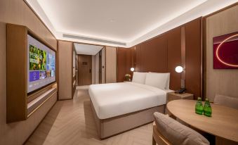 There is a large bed in the middle room of the hotel, accompanied by a table and chairs at Crystal Orange Beijing Shangdi Zhongguancun Software Park Hotel