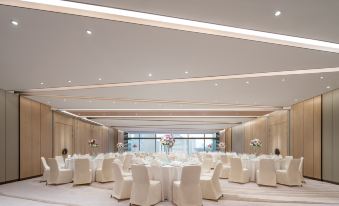 A spacious room is arranged with tables and chairs for hosting events at the hotel or conference at Conrad Shanghai