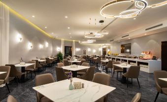 In the center of the restaurant, there are tables and chairs arranged in a way that they all face each other at Peony Hotel(Mudanyuan Subway Station)