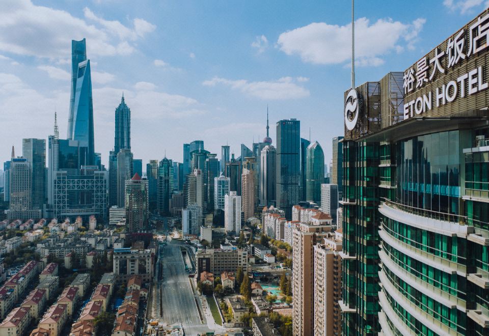 The cityscape features tall buildings and skyscrapers in the foreground, as viewed from a high vantage point at The Eton Hotel Shanghai