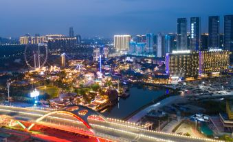 A city's illuminated skyline at night with buildings on both sides at Atour Hotel Shunde Happy Coast Foshan