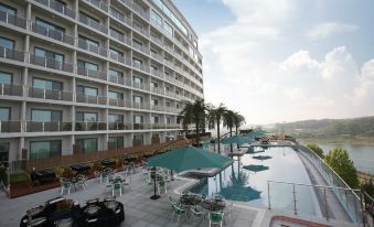 a large hotel with a swimming pool and outdoor dining area , surrounded by palm trees at Sun Valley Hotel