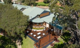 aerial view of a large house surrounded by trees and grass , with multiple decks and chairs on the lawn at Karriview