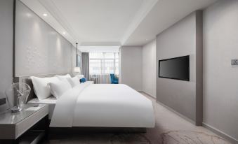 A modern bedroom features a large bed and a TV in the center, flanked by two walls at Byland Star Hotel (Yiwu International Trade City)
