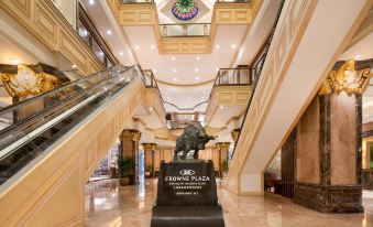 The lobby and entrance of this modern hotel feature an ornate ceiling in a large building at Crowne Plaza Shanghai Nanjing Road