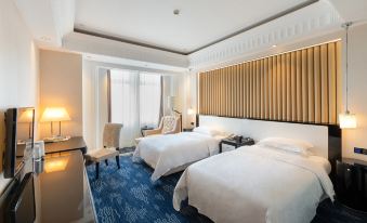 a bedroom with two large beds and a sitting area next to the window at Inspirock Hotel