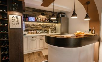 a modern kitchen with a black and white color scheme , featuring a bar area with stools and a sink at Villa Varosh