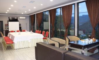 a large , empty conference room with multiple chairs and tables set up for meetings or events at Grand House hotel & zipline