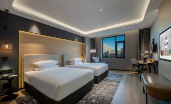 a contemporary bedroom with double beds and expansive city views from one side at Park Inn by Radisson Beijing Tongzhou Universal Resort
