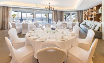 a large , round table with white tablecloths and chairs is set up for a formal event at DoubleTree by Hilton Malta