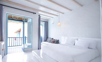 a white bedroom with two beds , one on the left and one on the right side of the room at Resort de Paskani