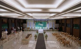 a large banquet hall with a long table and chairs set up for an event at Java Heritage Hotel Purwokerto