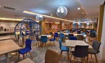 a modern restaurant with blue and white chairs arranged in a geometric pattern on the walls at Holiday Inn Express