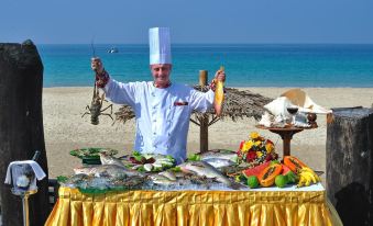 A man is standing on the street selling a variety of food and drinks at Aureum Palace Hotel & Resort Ngapali