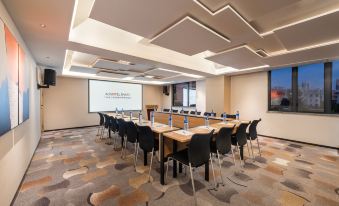 The hotel offers a spacious conference room equipped with long tables and chairs, suitable for meetings or other special events at Guangzhou Zhujiang New Town Ausotel Smart Hotel, Canton Fair Free Shuttle