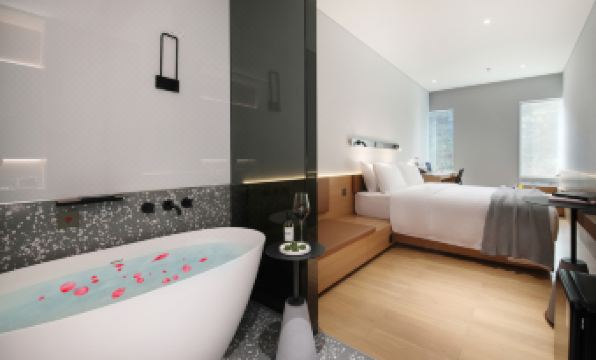 elegant and contemporary bedroom with a spacious bed and an adjoining bathroom at Insio Hotel (Shenzhen Shekou Maritime World)