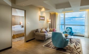 a well - decorated living room with a couch , chair , and coffee table in front of a window at DoubleTree Resort by Hilton Hotel Penang